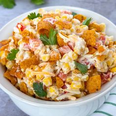 a white bowl filled with corn salad and garnished with cilantro