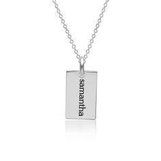 a small square pendant with the word,'happiness'in black ink on a silver chain