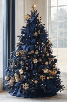 a blue christmas tree with gold and silver ornaments