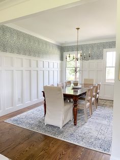 a dinning room table with chairs and a chandelier