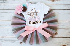 "The \"Western\" tutu set is made with layers of pastel pink, brown and blue tulle. This set includes options for a white shirt or bodysuit with the 'My First Rodeo' and a flower headband to match the colors in the set. Our tutus are made on a ribbon-tie waistband that ties and unties at the bow for a custom fit. Bodysuit size-------------------------Tutu/Outfit Size Newborn (5-9 pounds)------------NB tutu (12 inch waist, 6 inch length) 3 Month (9-12.5 pounds)---------0-3 month tutu (14 inch wai My First Rodeo Outfit, My First Rodeo Birthday Girl Smash Cake, First Rodeo Birthday Party Girl Outfit, My First Rodeo Birthday Girl Outfit, My First Rodeo Cake, My First Rodeo Birthday, 1st Rodeo Birthday Party Girl, My First Rodeo Birthday Girl