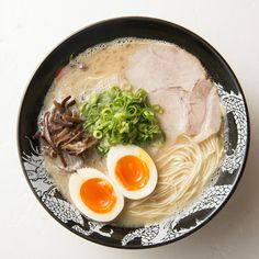 a bowl filled with ramen, meat and eggs