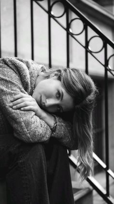 black and white photograph of a woman leaning on the stairs with her head resting on her hand