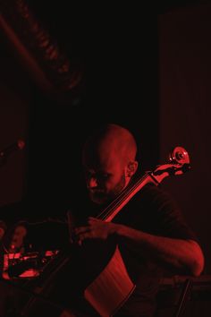 a man playing an instrument in the dark