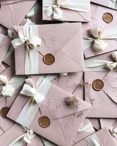 many pink envelopes with white ribbons and bows