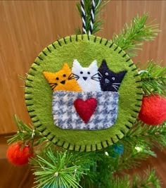 a green ornament with three cats in a basket on it's side