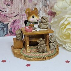 a figurine of a mouse sitting at a table