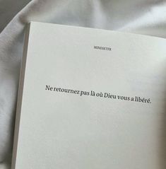 an open book laying on top of a white sheet covered in text that reads, ne retoure pas la divous a libere