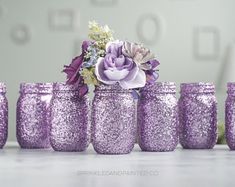 purple glitter mason jars with flowers in them