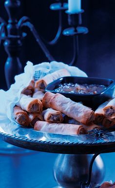 some food is sitting on a silver platter with a candle in the background and blue lighting