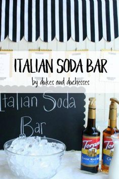 an italian soda bar with ice and drinks on the table next to it, in front of a chalkboard sign that says italian soda bar