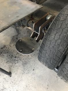 the front wheel and tire of a vehicle with no wheels on it, sitting in a garage