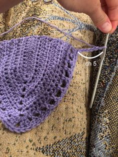 someone is crocheting the side of a purple bag