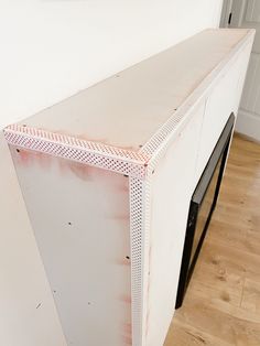 an unfinished kitchen counter with red paint on the top and bottom half, in front of a white wall