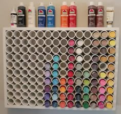 the wall is filled with different colored paint tubes