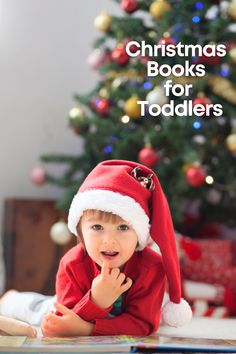 a little boy wearing a santa hat sitting in front of a christmas tree with the words christmas books for toddlers