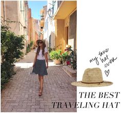 a woman in a hat and dress walking down a street with the words, the best traveling hat