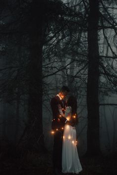 two people standing next to each other in the woods with lights on their foreheads