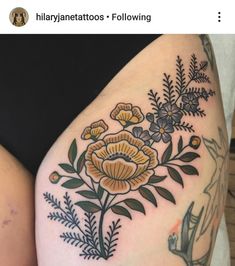 a woman's thigh with flowers and leaves on it