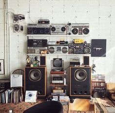 a room filled with lots of different types of speakers and audio equipment on the wall