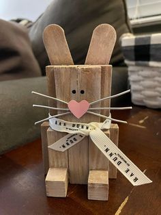 a wooden bunny with measuring tape around it's legs and ears, sitting on a table