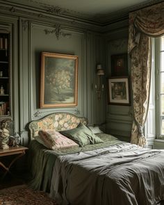 a bed sitting next to a window in a room with paintings on the wall above it