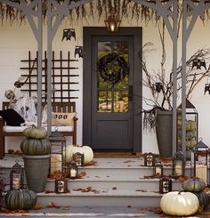 a front porch decorated for halloween with pumpkins and gourds