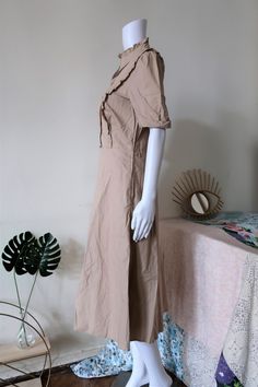 Beautiful Vintage safari dress from the 1990s. Comfortable cotton fabric in a versatile neutral colour, reminiscent of safari or military gear. Featuring a cute ruffle neck, puff sleeves, ruffles along the front, a lined skirt, zipper on the left, side pockets and belt loops. Slightly flared midi skirt. Very comfortable and versatile for warm summer days. BRAND: Betty Barclay COLOUR: Sand FABRIC: 100% cotton SIZE: Vintage size 40, fits best size M (or S for a more relaxed fit) - please check mea Beige Short Sleeve Midi Dress With Ruffles, Beige Midi Dress With Ruffles And Short Sleeves, Casual Beige Midi Dress With Ruffles, Beige Cotton Midi Dress With Puff Sleeves, Beige Midi Dress With Ruffle Hem And Short Sleeves, Flared Midi Skirt, Vintage Safari, Safari Dress, Dress With Puff Sleeves