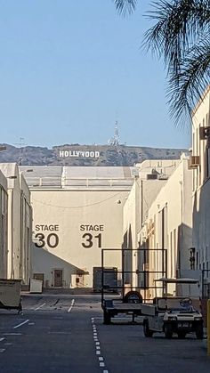 an empty parking lot in front of the hollywood sign and movie theater building with palm trees