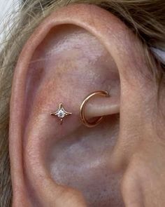 a person wearing an ear piercing with a star and moon on it