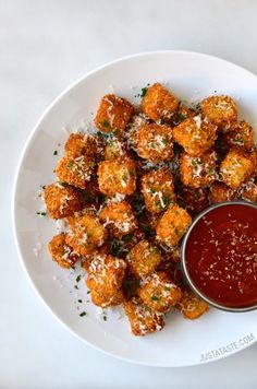 a white plate topped with tater tots covered in cheese and ketchup