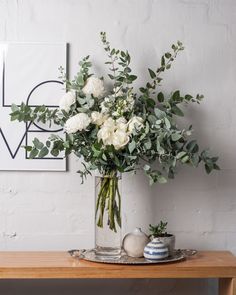 a vase filled with white flowers on top of a wooden table