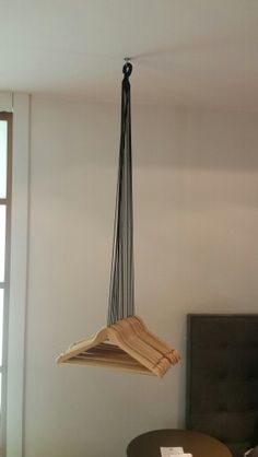 a room with a bed, table and hanging object in the air over it's headboard