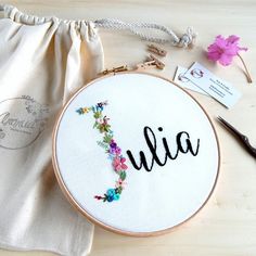 a cross stitch project with the word julia on it and some scissors next to it