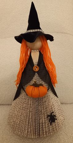 a doll made out of an accordion with orange hair and a witch's hat