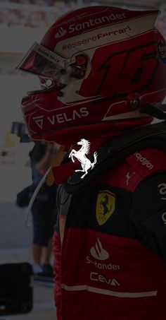 the back view of a person wearing a red racing suit and helmet with ferrari logo on it