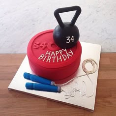 a red cake with a kettle and scissors on it