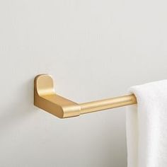 a gold towel holder on a white wall