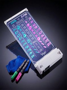 an electronic device with writing on the screen and two markers next to it, all lit up