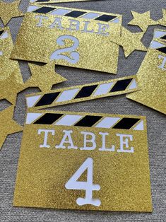 gold glitter table numbers and clapsticks for a movie themed birthday party