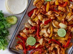 chicken fajita with peppers, onions and cilantro on a baking sheet