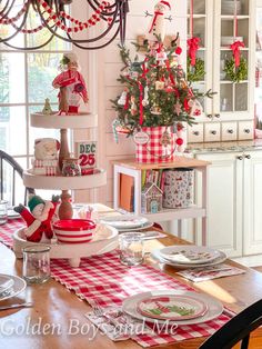 a dining room table set for christmas with plates, cups and bowls on the table