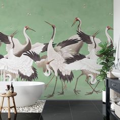 there are many birds painted on the wall next to this bathtub and shower tub