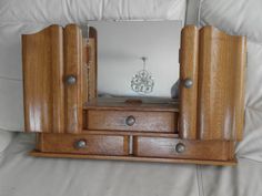 a wooden dresser with mirror and drawers on it's sides in front of a white couch