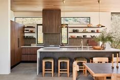 an open kitchen and dining area with wooden furniture