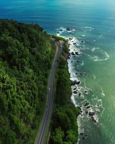 an aerial view of the ocean and road