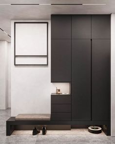 a modern bathroom with black cabinets and white walls, along with shoes on the floor