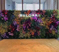 an artificial flower wall is shown in front of a window with the word bvglart written on it