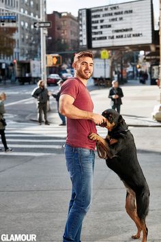 a man is playing with his dog on the street