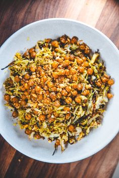 a white bowl filled with food on top of a wooden table